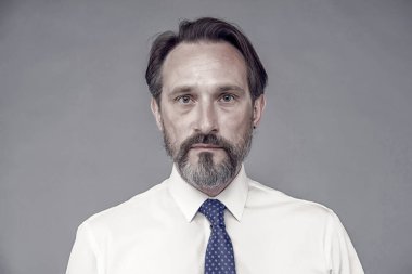 Kendine güvenen ve yakışıklı bir adam. Erkek resmi moda. Başarılı bir iş adamı gömlek ve kravat giyer. Ofis çalışanı. Erkek berber bakımı. Olgun iş adamının saçları beyazlamış.