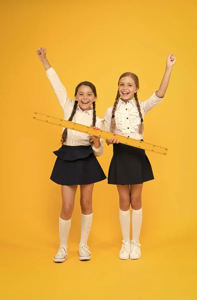 Equipo de medición. Los niños estudian matemáticas. Día del conocimiento. El uniforme escolar de las colegialas tiene una gran regla. Escuela de geometría. Concepto de trabajo en equipo. Cerca o lejos. Midiendo habilidades. Distancia de medición —  Fotos de Stock