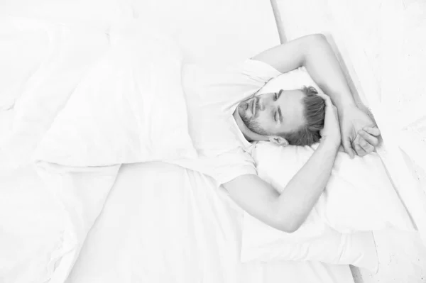 Sağlıklı uyku alışkanlıklarını destekleyen ipuçları. Yatakta dinlenen yakışıklı adam. Düzenli olarak geceleri uyuyun. Yatmadan önce meditasyon gibi sakinleştirici aktiviteler üzerinde çalış. Sağlıklı uyku konsepti — Stok fotoğraf