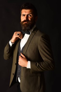 Eskimiş şık takım elbiseli ve kahverengi arka planda yelek giyen adam..