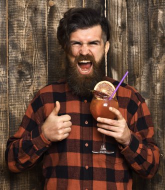 Şık gömlekli vahşi sakallı adam sert bir içki tutuyor..