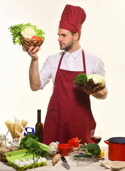 Cook står vid bordet med köksutrustning och ingredienser. — Stockfoto