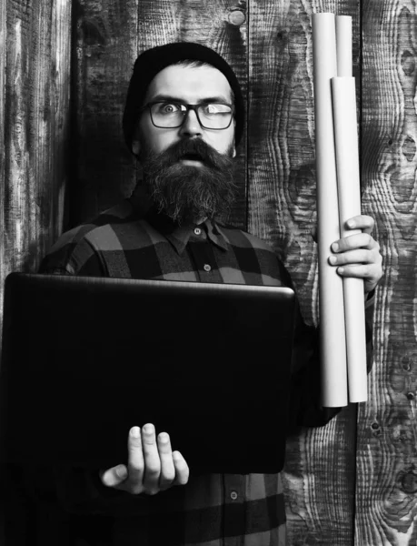 Kaba sakallı, beyaz tenli hippi elinde dizüstü bilgisayar ve el işi kâğıdı tutuyor. — Stok fotoğraf