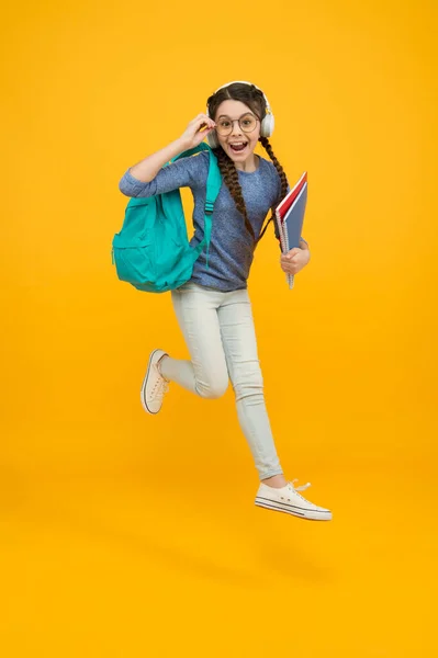 Ατρόμητη παιδική ηλικία. Ευτυχισμένο παιδί σε κίτρινο φόντο. Κοριτσάκι πίσω στο σχολείο. Ώρα για σχολείο. Ανάπτυξη της παιδικής ηλικίας και εκπαίδευση. Παιδική δραστηριότητα. Παιδικό όνειρο για το μέλλον — Φωτογραφία Αρχείου