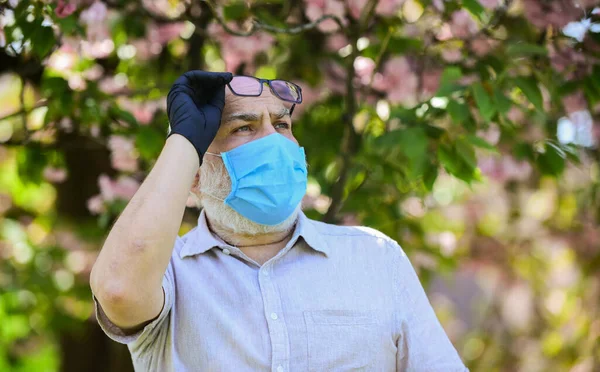 Pandemic concept. Limit risk infection spreading. Senior man wearing face mask and gloves outdoors. Older people at highest risk from covid-19. Infection is in air. Protect and from virus infection