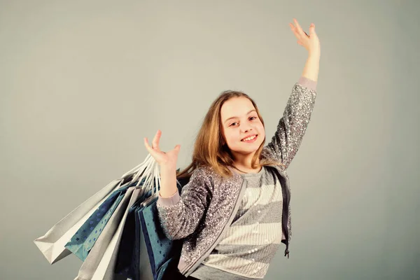 Centro comercial. Ahorro de compra vacaciones. Ir de compras. Ventas y descuentos. Moda infantil. asistente de tienda con paquete. Niña pequeña con bolsas de compras. Feliz niña. Niña con regalos. cliente en el centro comercial —  Fotos de Stock