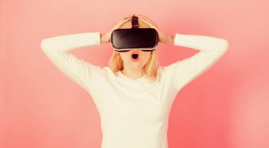 3D aygıt teknolojisi deneyimi olan komik bir kadın. Yakın çekim. Sanal gerçeklik gözlüğü takan heyecanlı bir iş kadını. Kendine güvenen genç bir kadın sanal gerçeklik kulaklığını ayarlıyor ve gülümsüyor..