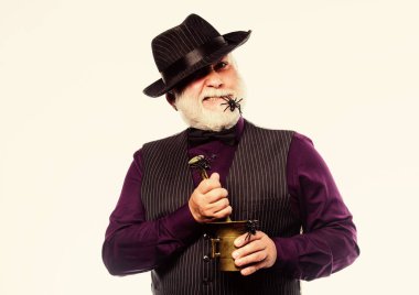 Gri sakallı ve örümcekli garip yaşlı barmen. Sihirli içeceği hazırlıyorum. Cadılar Bayramı konsepti Tuhaf insanlar. Şık bir barmen şapka ve yelek giyer ve içki hazırlar. Korku partisi. Korkunç barmen.