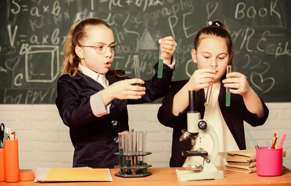 Microscoop en reageerbuizen op tafel. Voer chemische reacties uit. Basiskennis van de chemie. Meisjes studeren scheikunde. Dat maakt scheikunde interessant. Educatief experimenteel concept — Stockfoto