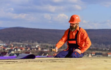 Düz çatı kurulumu. Roofer yeni çatı yapıyor. Projeler için tahmini malzeme gereksinimleri. Çatı malzemeleri yükleyin. Isı yalıtımı. Çatıda adam var. Profesyonel tamir çatısı.