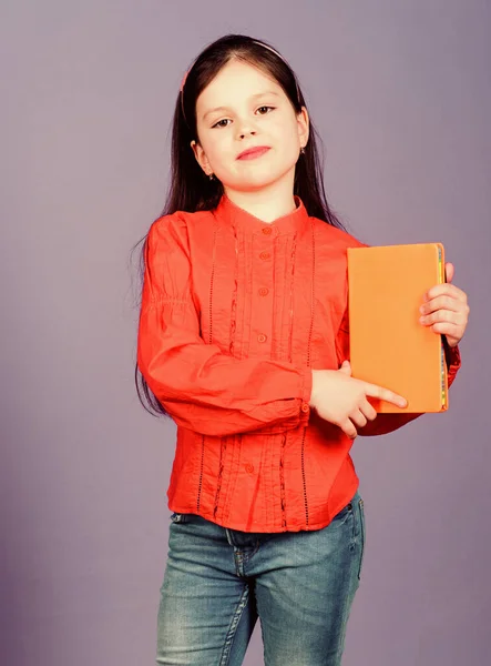 Girl hold book violet background. Kid show book. Book concept. Literature club. Development and education. Reading skill. Personal diary. Textbook presentation. Study and learn. Poetry author — Stock Photo, Image