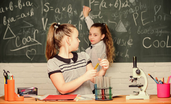 Back to school. School classes. Girls study chemistry in school. Microscope test tubes chemical reactions. Pupils at chalkboard. Fascinating science. Formal education school. Educational experiment