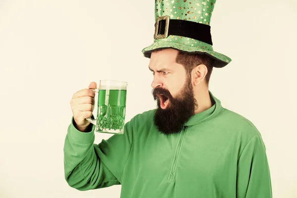 Irländsk tills jag svimmar. Hipster i pysslad hatt med ölmugg. Irländsk man med skägg dricker grön öl. Skäggig man som skålar för helgonets patricks dag. Fira helgon patricks dag i baren — Stockfoto