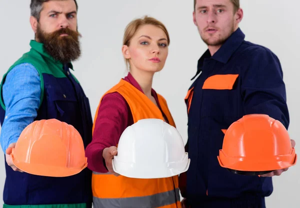 Men and woman wears uniform and holds helmets — Stock Photo, Image