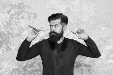 Lüks hizmet. Vahşi berber dükkanı müdürü. Sakallı berber kuaför aletleri tutuyor. Yeni bir saç stili yaratmak. Berber dükkanı saç kesiminin eski donanımı. Bıçak ve makas. Uzun sakallı ciddi bir adam.