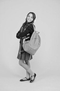 Kitap ve özel ders konsepti. Sırt çantalı küçük bir kız kulaklığı. Ceketinde İngiliz bayrağı olan çocuk. İnternette İngilizce öğreniyorum. İngiltere 'deki İngiliz okulu. Ses kitabıyla İngilizce öğrenme