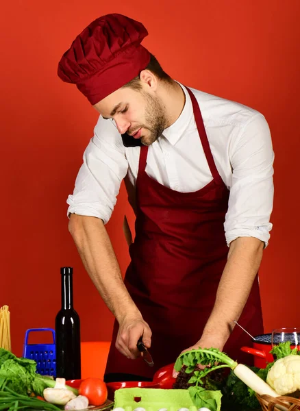 Mannen i kockmössa och förkläde hackar peppar. Vegetariskt mjöl — Stockfoto