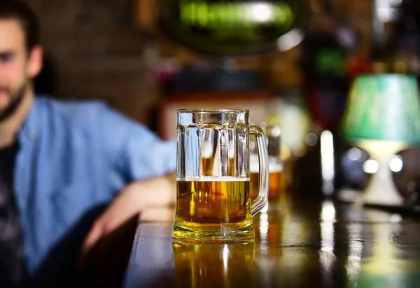 Homem senta-se atrás de vidro de cerveja leve . — Fotografia de Stock