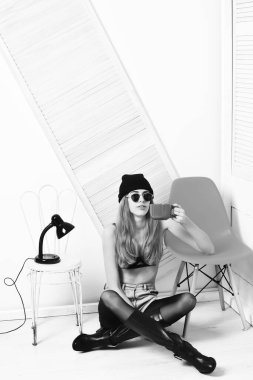 Turuncu güneş gözlüklü, açık yeşil sandalyeli güzel seksi kadın.