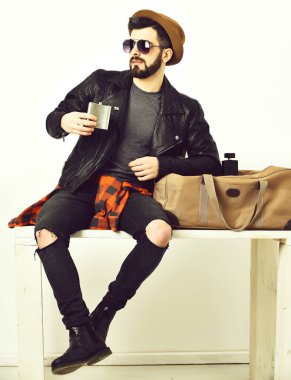 Sakallı, beyaz, bıyıklı, elinde matarası olan bir hippi.