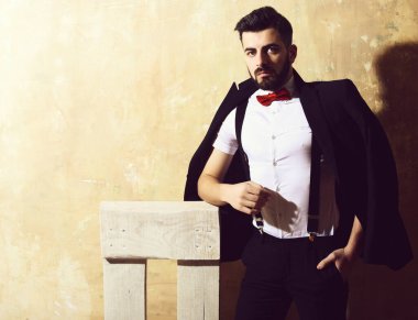 Stüdyo duvarında ciddi bir yüzü olan sakallı bir adam.