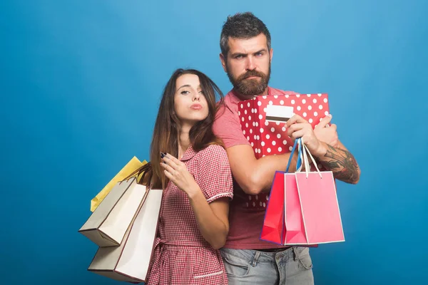 Couple in love stands back to back holding shopping bags