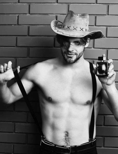 Caucásico barbudo sexy macho hombre en vaquero sombrero celebración perfume — Foto de Stock