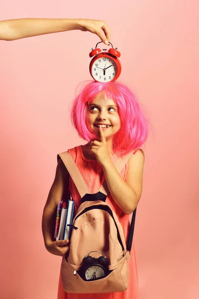 Pupil in school uniform with pink wig and red alarm — Stock Photo, Image