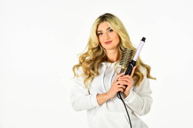 Kuaför ipuçları. Sevimli sarışın kız. Alet al. Çevrimiçi iş. Herkesin bilmesi gereken yararlı saç maşası hileleri. Saç stilini saç maşasıyla oluşturun. Uzun kıvırcık saçlı kadın saç maşası kullanıyor.