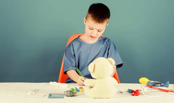 Pediatrician intern. little boy in medical uniform. kid doctor with stethoscope. hospital. medicine and health. Treatment prescription. nurse laboratory assistant. family doctor. playing with toy — Stock Photo, Image