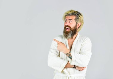 Hijyen ve kaplıca. Spa tesisi. Otel daireleri. Beyaz bornoz giyen sakallı adam. Olgun bir adam spa 'da rahatlatıcı bornoz giyer. Uyku alışkanlıklarını geliştirmek için adımlar at. Banyoda bornozlu bir adam.