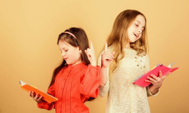 Eğitim ve çocuk edebiyatı. Favori peri masalı. Okula dönelim. Kardeşler birlikte okumak için kitap seçerler. Sevimli kızlar kitapları sever. Okuma yazma bilinci sayesinde kapıları açmak. Kitap ya da not defteri olan çocuklar.
