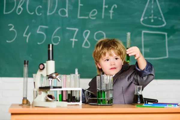 Um rapazinho na aula. De volta à escola. experimentos científicos com microscópio em laboratório. O rapazinho está a fazer experiências. Cientista universitário a estudar ciências. Ciências Biológicas. A ciência vale a pena explorar — Fotografia de Stock