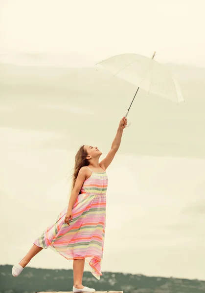 気楽な子供時代。傘を差した少女。雨の日だ。秋の気分だ。秋の天気予報。秋のファッション。自由と幸福。どんな天気でも気分がいい — ストック写真