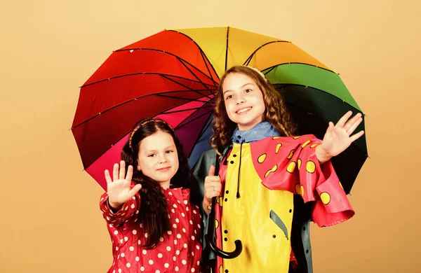 Joyeuses petites filles avec parapluie coloré. mode d'automne. joyeux enfants hipster, fraternité. protection contre la pluie. Arc en ciel. liens familiaux. Des petites filles en imperméable. Air frais et bonne humeur — Photo