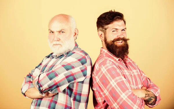Brutal guys with long beard. Father and son. Hairdresser salon. Barbershop concept. Men bearded hipster stand back to back. Bearded friends. Family team. Barber well groomed handsome bearded man