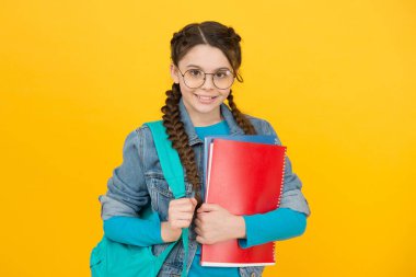 Kütüphane seni hayalperest yapıyor. Kütüphane okuyucusu sarı arka plan. Mutlu kız kütüphane kitaplarını tutuyor. Akıllı kitap kurdu. Okul kütüphanesi. Bilgi ve bilgi. Bibliopol. Kitapçı. İncil Cenneti