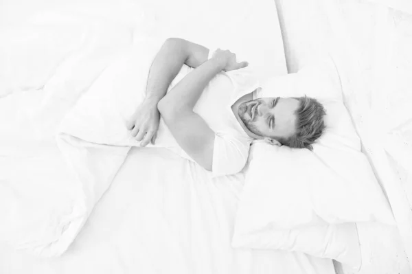 Uyku problemleri sabahları baş ağrılarına yol açabilir. Migren ağrısı. Yatakta dinlenen yakışıklı adam. Horlamak baş ağrısını artırabilir. Uyku apnesinin yaygın belirtileri. Sabahın erken saatlerinde baş ağrısı. — Stok fotoğraf
