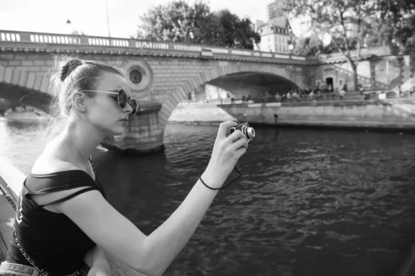 Beste Kamera für Touristen. Hübscher Fotograf fotografiert Stadtfluss. Sexy Mädchen schießen mit der Kamera. Kompakte Reisekamera. Kamera zum Fotografieren von Reisen in den Urlaub. Reisen und Urlaub — Stockfoto