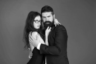 Biz farklıyız ama birbirimizi seviyoruz. Kırmızı arka planda aşık bir çift. Sakallı adam seksi kadına sarıldı. Aşk randevusu ve randevu. Aşk ve romantizm. Romantik bir ilişki. Sevgililer Günü
