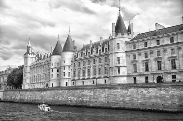 Palast auf einem steinernen Damm. Bootstour. Palais de la Cite in Paris Frankreich. Palastgebäude mit Türmen und Türmen. Denkmal der gotischen Architektur und des gotischen Designs. Urlaub und Fernweh in der französischen Hauptstadt — Stockfoto