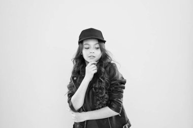 Nasıl hippi olunur. Şık deri ceketli mutlu çocuk. Küçük kız sadece düşünüyor. Çocuk modası konsepti. Çocuğun uzun kıvırcık saçları var. Kuaföre gittikten sonra. Şapkaya baksan iyi olur. Çok havalı görünüyorsun.