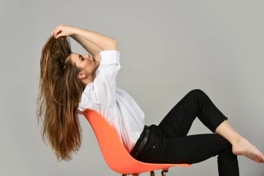 Harika bir tarzı var. Zarif bir manken. Kızlar ofis gömleği ve pantolonu giyer. Onun gündelik tarzı. Şık bir iş kadını. Seksi kadın sandalyeye uzan. Kadın güzelliği ve moda. Kuaför Güzellik Salonu