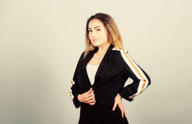 Zarif ve atletik parçaları karıştırıyorum. Spor kıyafetleri podyumlarda kural koyuyor. Mavi arka planda gülümseyen bir kadın. Voluminous kıvrımlı saç stili. Moda kıvrımlı saç stili. Spor şıklığı