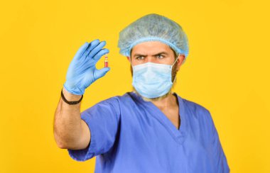 Tıbbi uzmanlar test tüpünü tutuyorlar, seçici odaklanma. Doktor solunum maskesi takıyor. Coronavirus aşısı olan bir hemşire. Salgın ya da grip tedavisi. Dokunulmazlığı var. Yeni tip zatürree. Doktorlar semptomlar üzerinde çalışır.