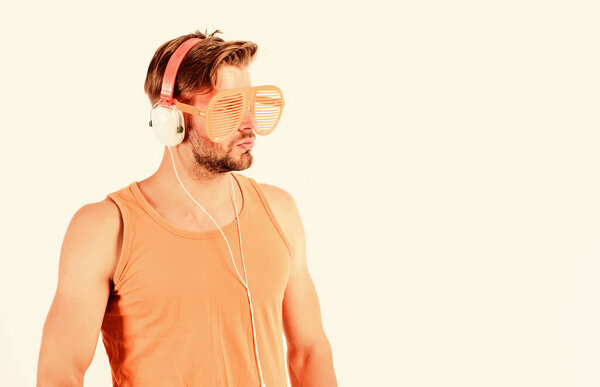 Guy unshaven face listening summer music. Dj boy. Technology and entertainment. Modern life. Handsome man with headphones and sunglasses. Party concept. Summer music chart. Popular summer track list