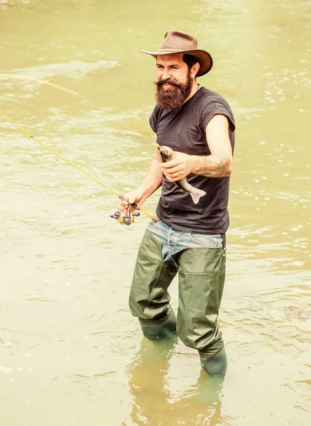 Big Game Sport Fishing. summer weekend. Fly fishing. fisherman show fishing technique use rod. hobby and sport activity. Happy bearded fisher in water. mature man fly fishing. man catching fish