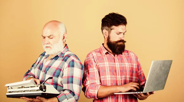 Competitors. father and son. family generation. technology battle. Modern life. retro typewriter vs laptop. New technology. youth vs old age. business approach. two bearded men. Vintage typewriter — Stock Photo, Image