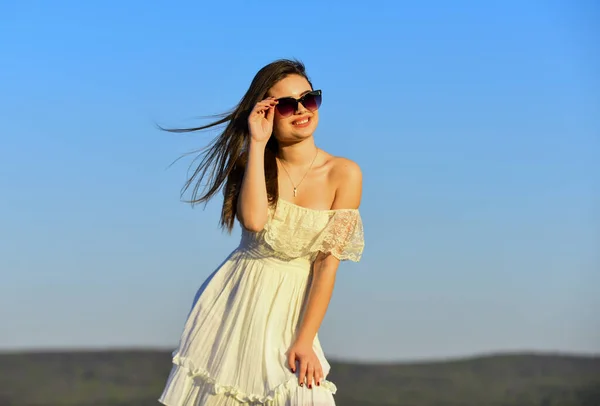 Tijd om te ontspannen. strand mode stijl. Zomer buiten levensstijl. Gelukkige jonge vrouw poserend boven de blauwe lucht. mooie jonge mooie vrouw met een zonnebril. Zomer outfit. Portret van het mooie meisje — Stockfoto