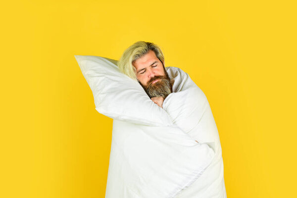 Morning sleepiness. tiredness and insomnia. brutal bearded hipster relax at home. cozy white bedroom. early wake up. lazy sunday. morning sex concept. mens health. bachelor man wrapped in blanket